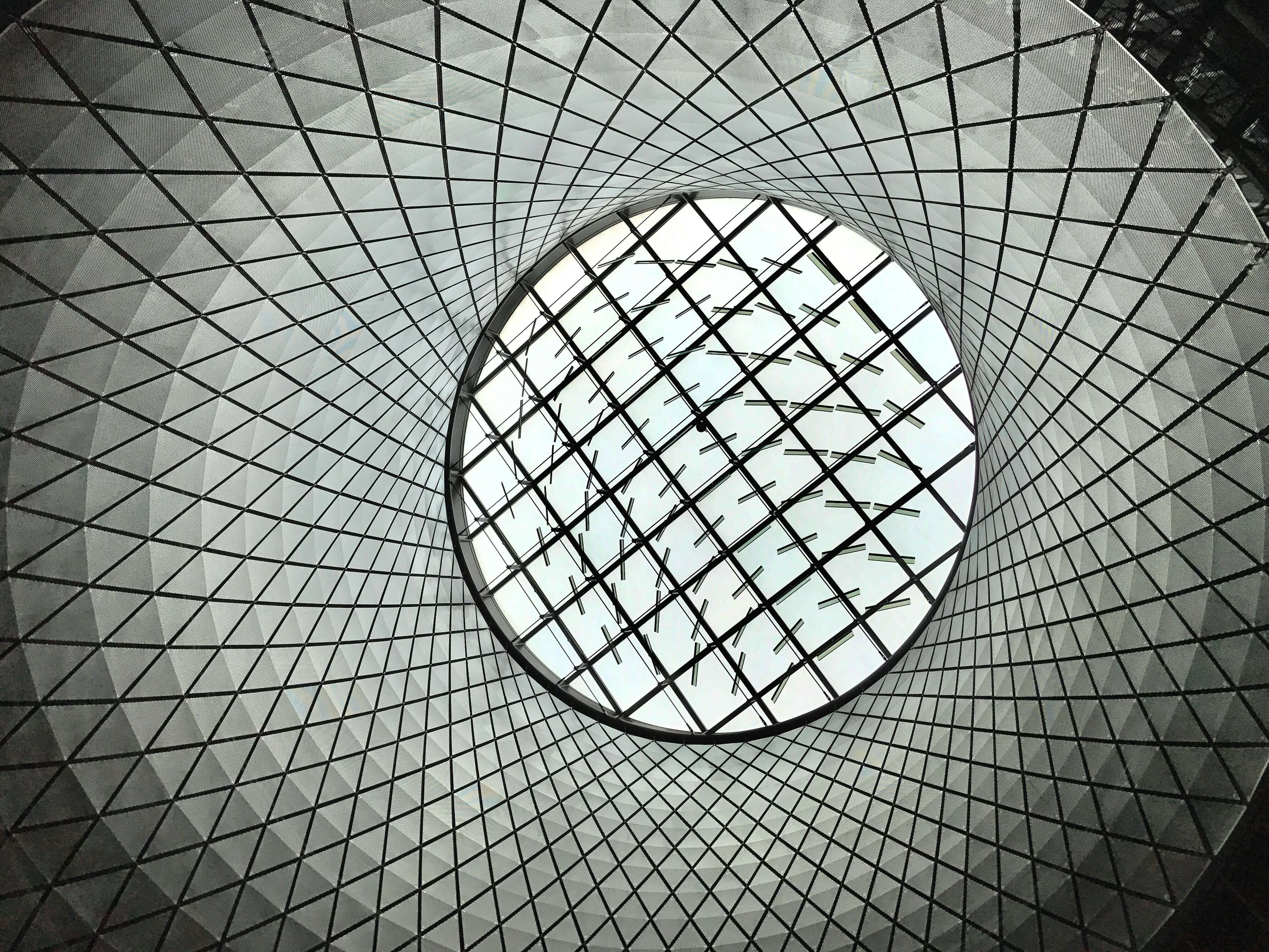 A circular skylight featuring a geometric pattern, illustrating the clarity and vision that Caldera Capital brings to every financial transaction.