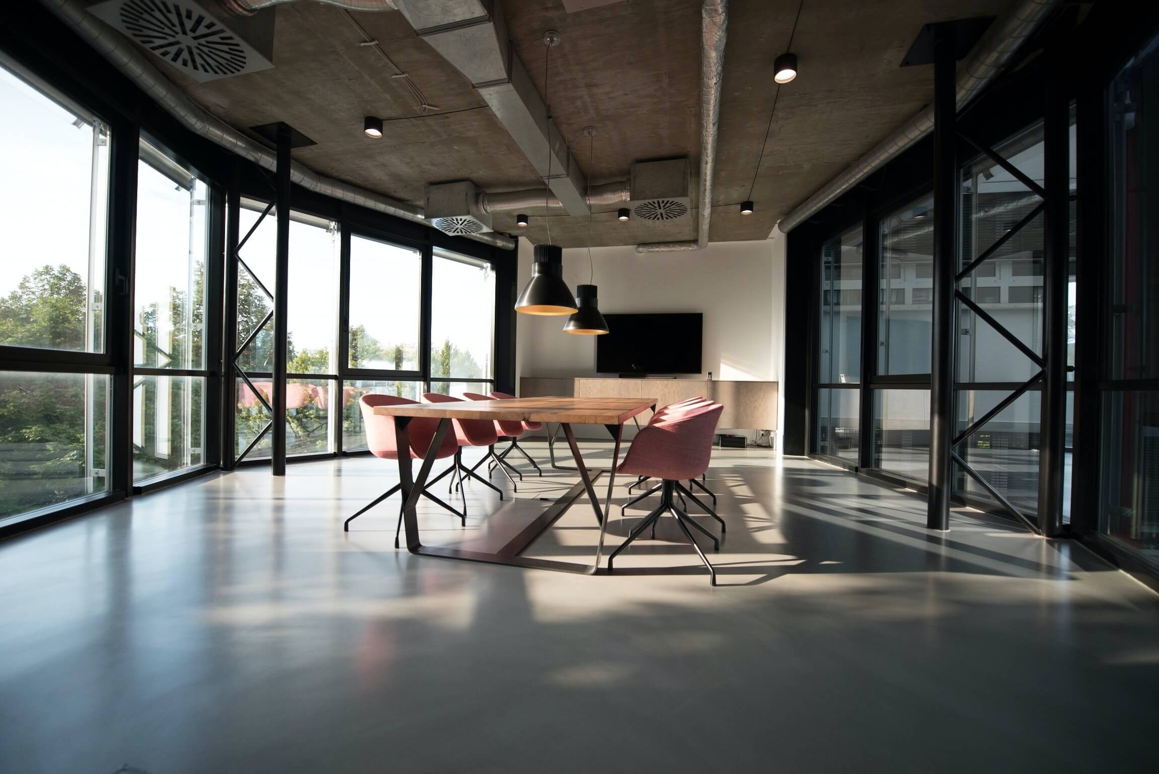 Sleek office interior with a spacious wooden table and modern design chairs, reflecting the professional and strategic environment for corporate finance consulting