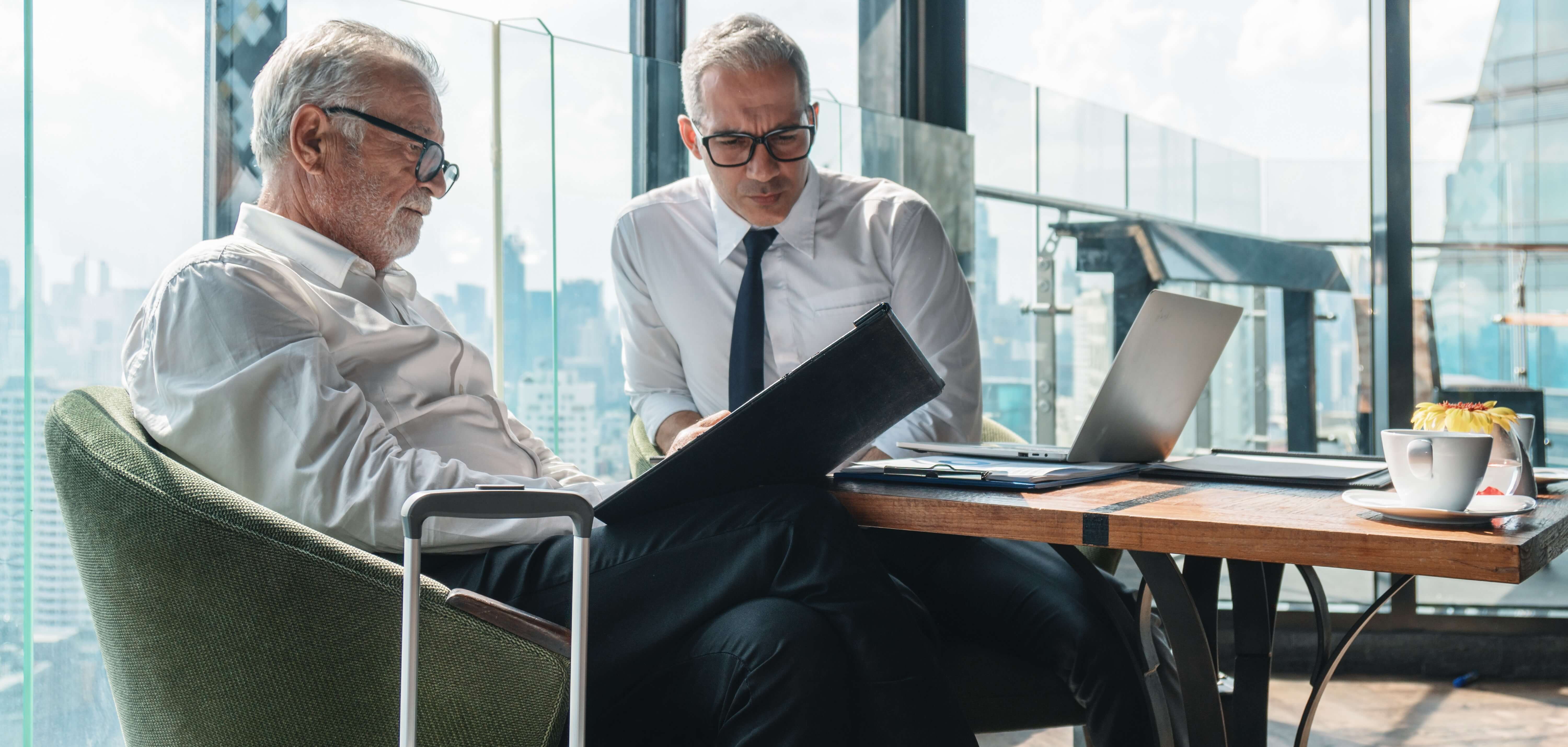 Senior executives strategising over documents, depicting the commitment to rigorous analysis and strategic partnership development.