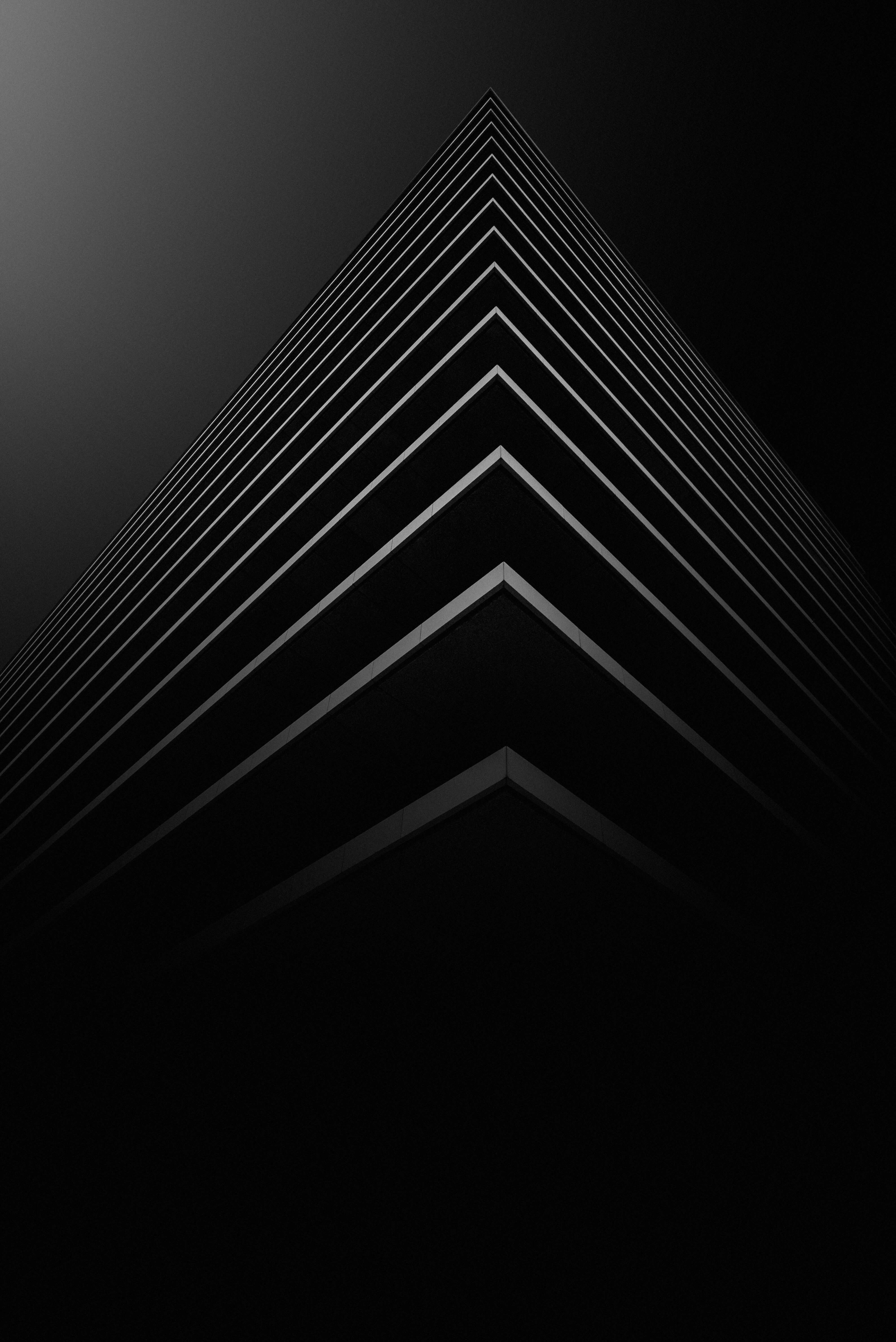 Dark, angular architectural design under artificial lights, resonating with Caldera Capital's approach to illuminating strategic pathways in complex financial transactions.